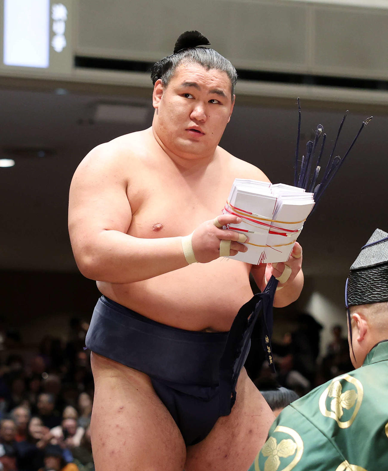 懸賞金の束を手に土俵を引き揚げる豊昇龍（撮影・鈴木正人）　