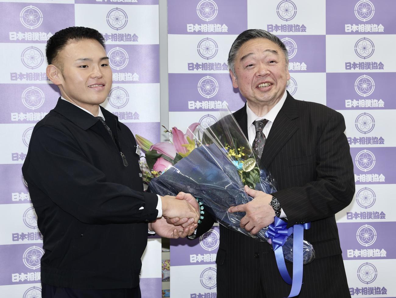 湊川親方（左）から花束を受け取る常盤山親方（撮影・河田真司）