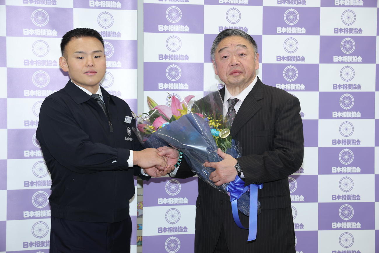 湊川親方（左）から花束を受け取る常盤山親方（撮影・河田真司）
