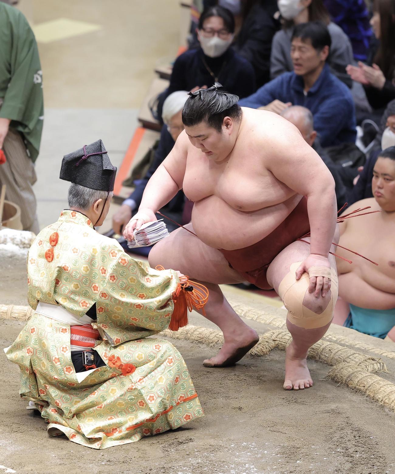 霧島を浴びせ倒しで破り、懸賞金の束を手にする熱海富士（撮影・河田真司）