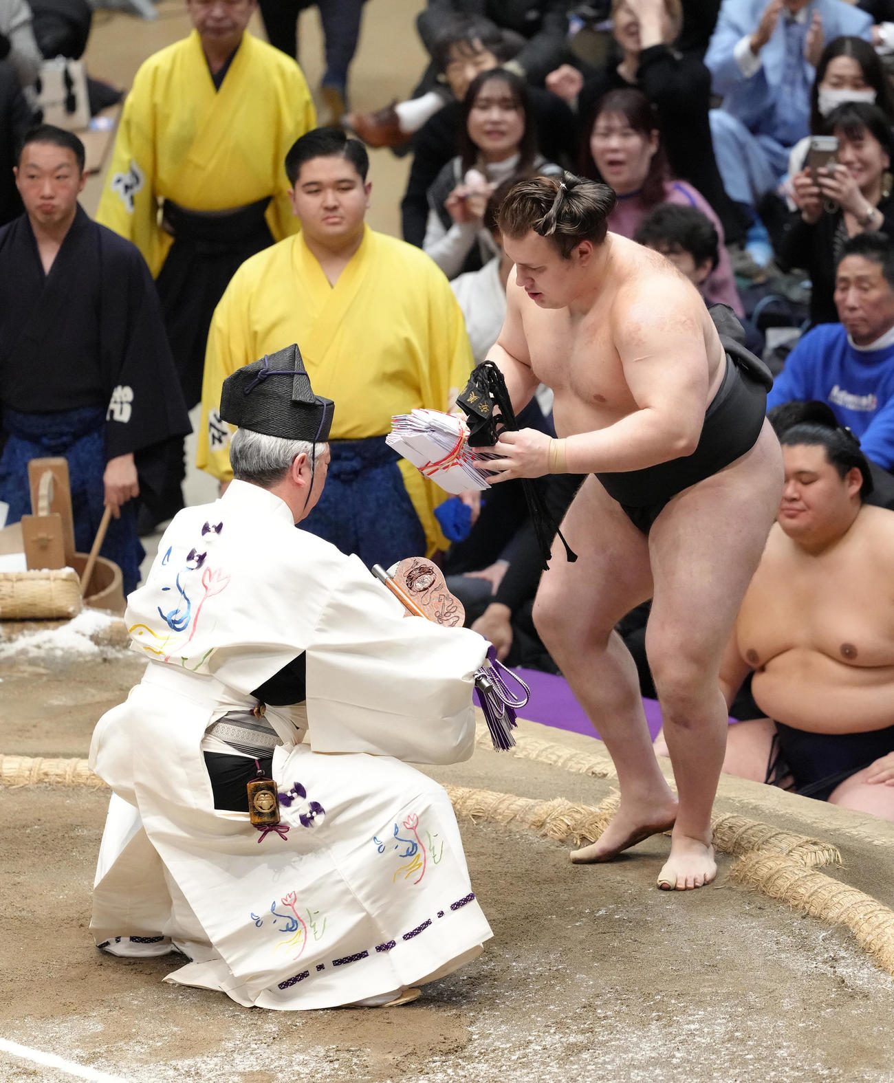 琴桜を寄り切りで破り懸賞を手にする安青錦（撮影・足立雅史）