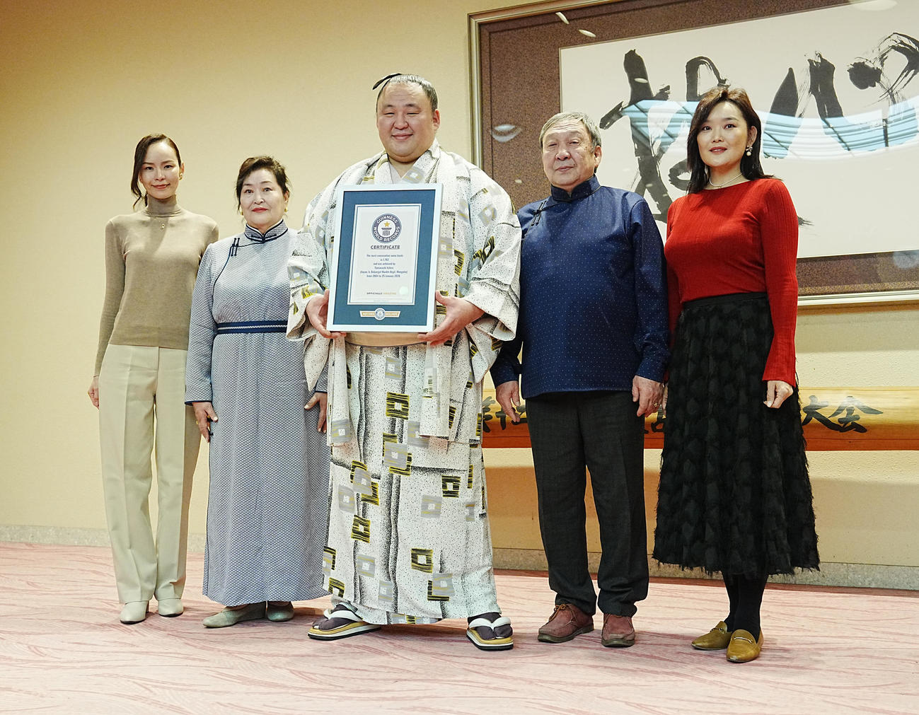 ギネスワールドレコーズジャパンから「大相撲最多連続出場」ギネス世界記録2026の公式認定証を贈呈され家族と記念撮影する玉鷲（中央）。左からミシェル夫人、母ツェンデスレンさん、1人おいて父バトジャルガルさん、姉ムンフズルさん（撮影・小沢裕）