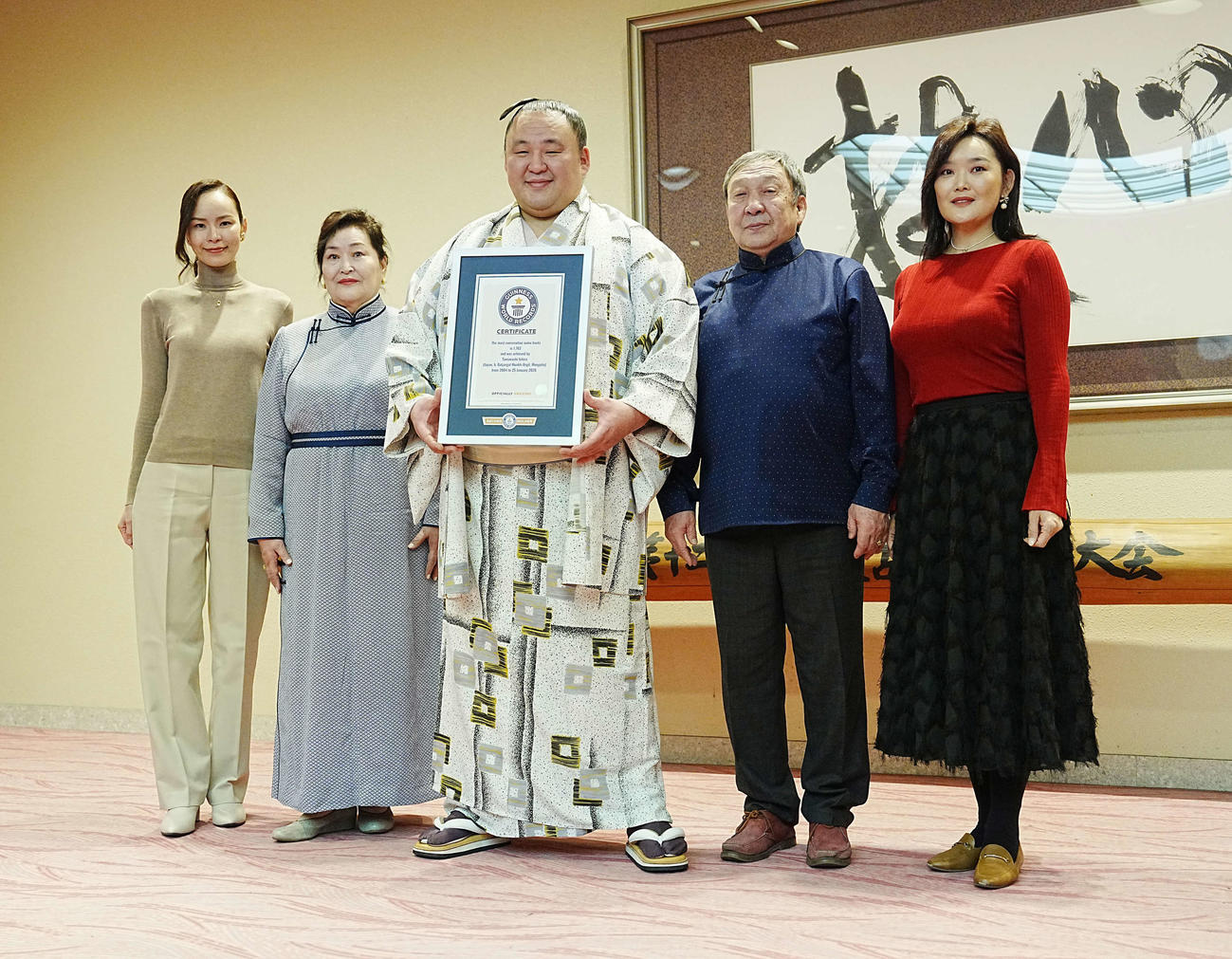 ギネスワールドレコーズジャパンから「大相撲最多連続出場」ギネス世界記録2026の公式認定証を贈呈され家族と記念撮影する玉鷲（中央）。左からミシェル夫人、母ツェンデスレンさん、1人おいて父バトジャルガルさん、姉ムンフズルさん（撮影・小沢裕）