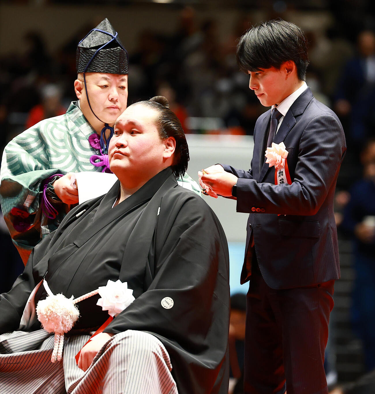 元横綱照ノ富士の伊勢ケ浜親方（左）の断髪式ではさみを入れる加藤凌平氏（撮影・野上伸悟）