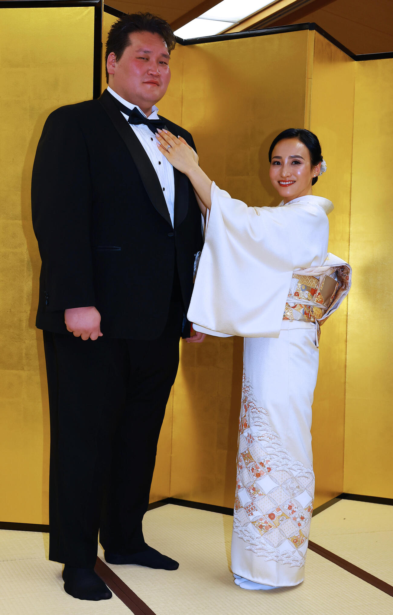 断髪式を終えた元横綱照ノ富士の伊勢ケ浜親方（左）は、整髪後にドルジハンド夫人にネクタイを直される（撮影・野上伸悟）