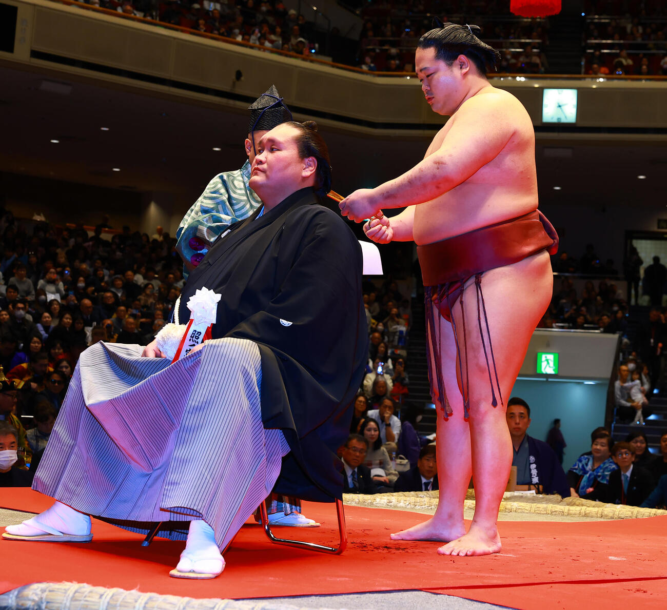 元横綱照ノ富士の伊勢ケ浜親方（左）の断髪式ではさみを入れる錦富士（撮影・野上伸悟）