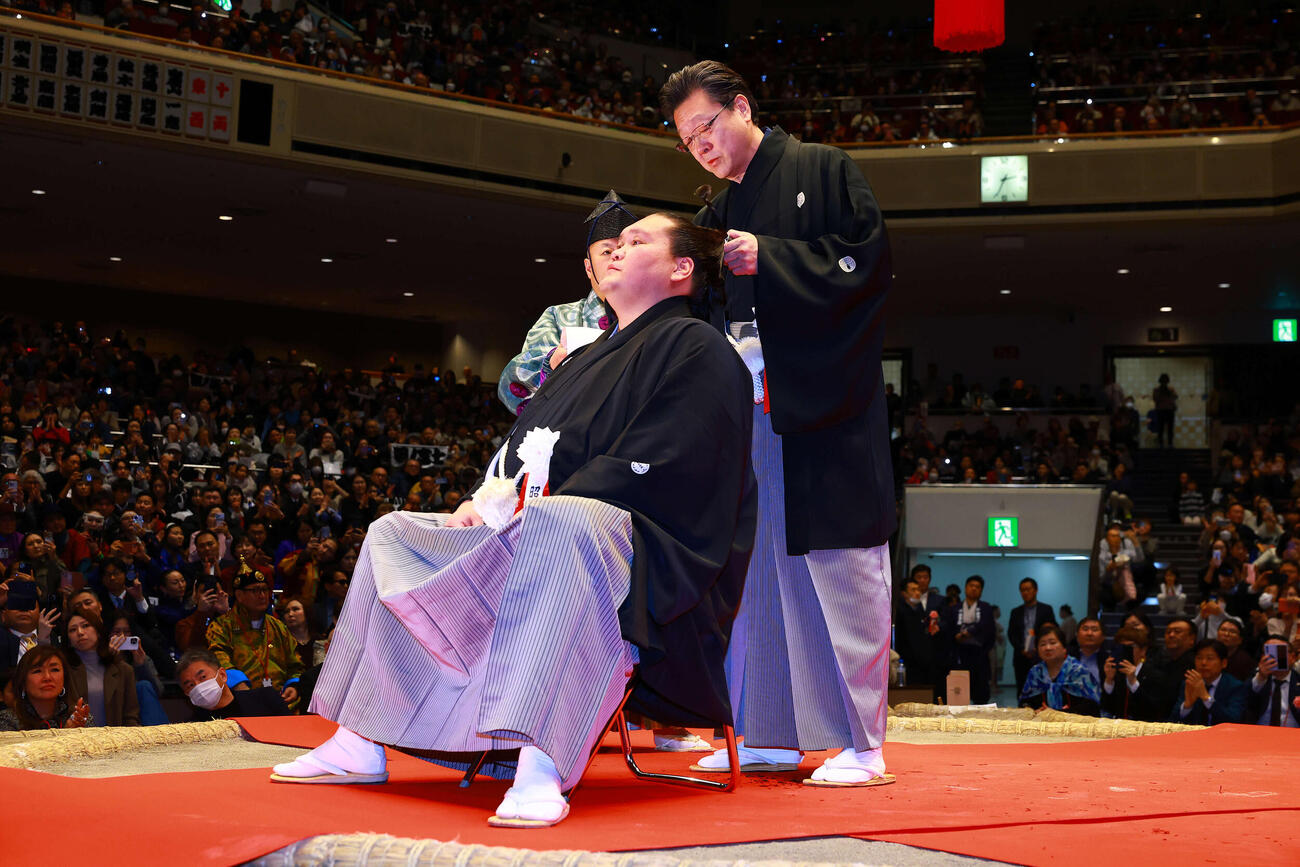 断髪式で、先代伊勢ケ浜親方の宮城野親方（右）に止めばさみを入れられる元照ノ富士の伊勢ケ浜親方（撮影・野上伸悟）