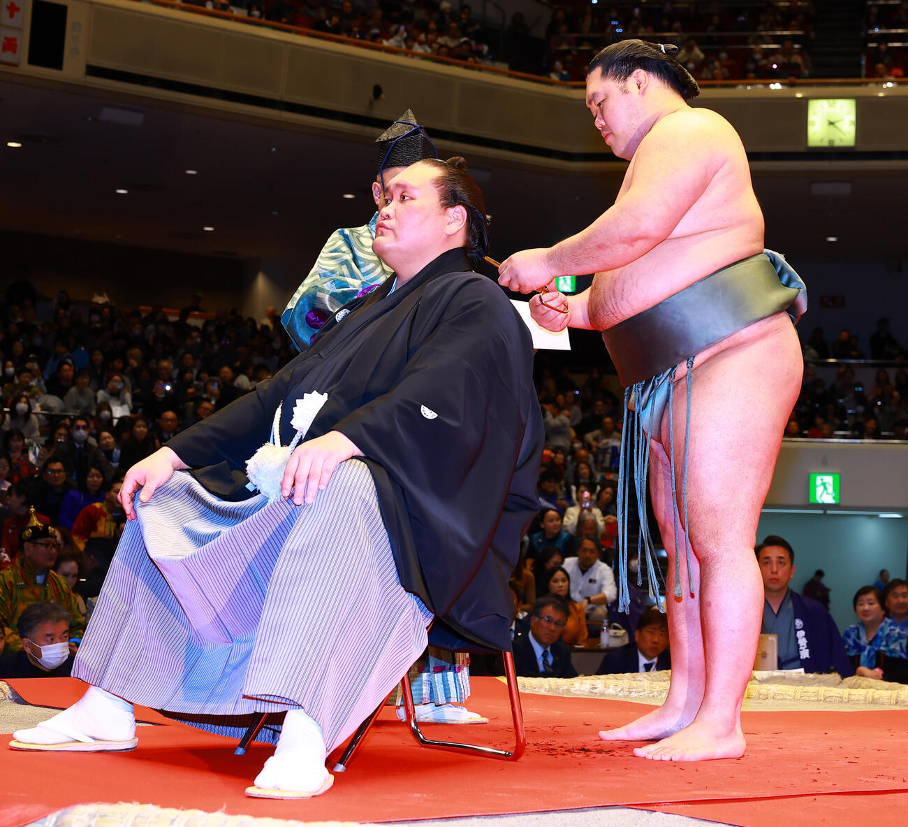 元横綱照ノ富士の伊勢ケ浜親方（左）の断髪式ではさみを入れる明生（撮影・野上伸悟）