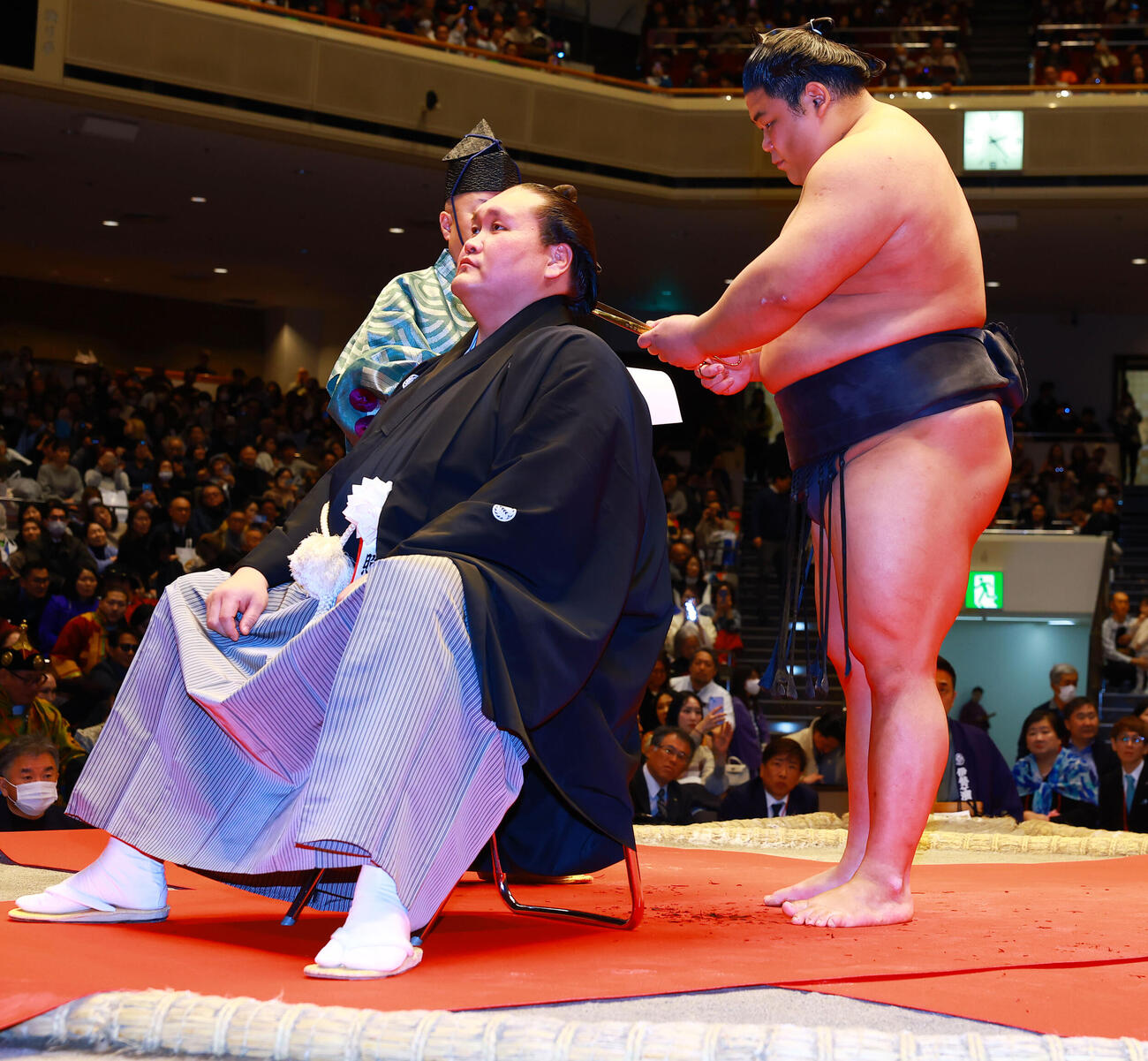 元横綱照ノ富士の伊勢ケ浜親方（左）の断髪式ではさみを入れる伯乃富士（撮影・野上伸悟）