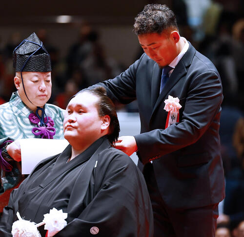 元横綱照ノ富士の伊勢ケ浜親方（左）の断髪式ではさみを入れる中田翔氏（撮影・野上伸悟）