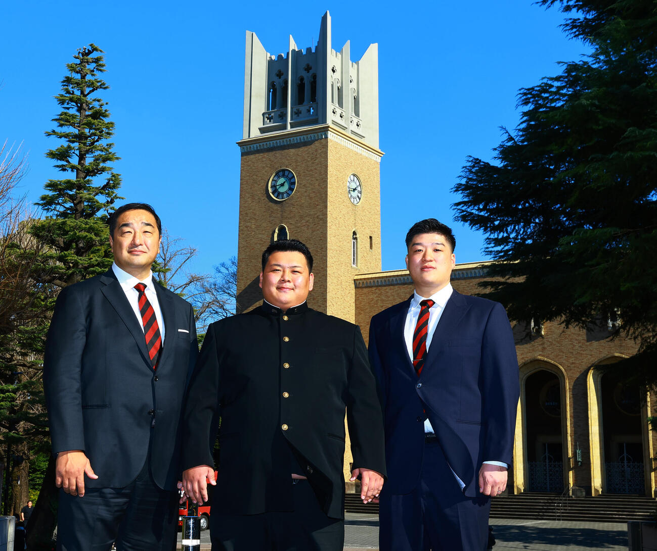 安治川部屋入門が決まった早大・川副（中央）は、早大大隈講堂を背に安治川親方（左）、相撲部監督の橋本監督と記念撮影（撮影・野上伸悟）