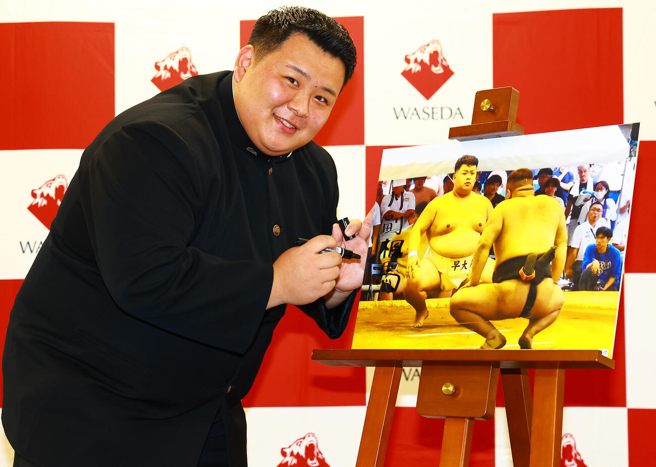安治川部屋入門が決まり、パネルにサインする早大・川副（撮影・野上伸悟）