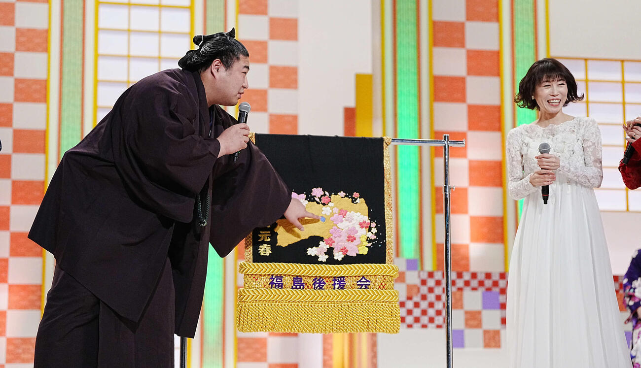 NHK福祉大相撲のお楽しみ歌くらべで母がデザインした化粧まわしを披露する若元春。右は水森かおり（撮影・小沢裕）