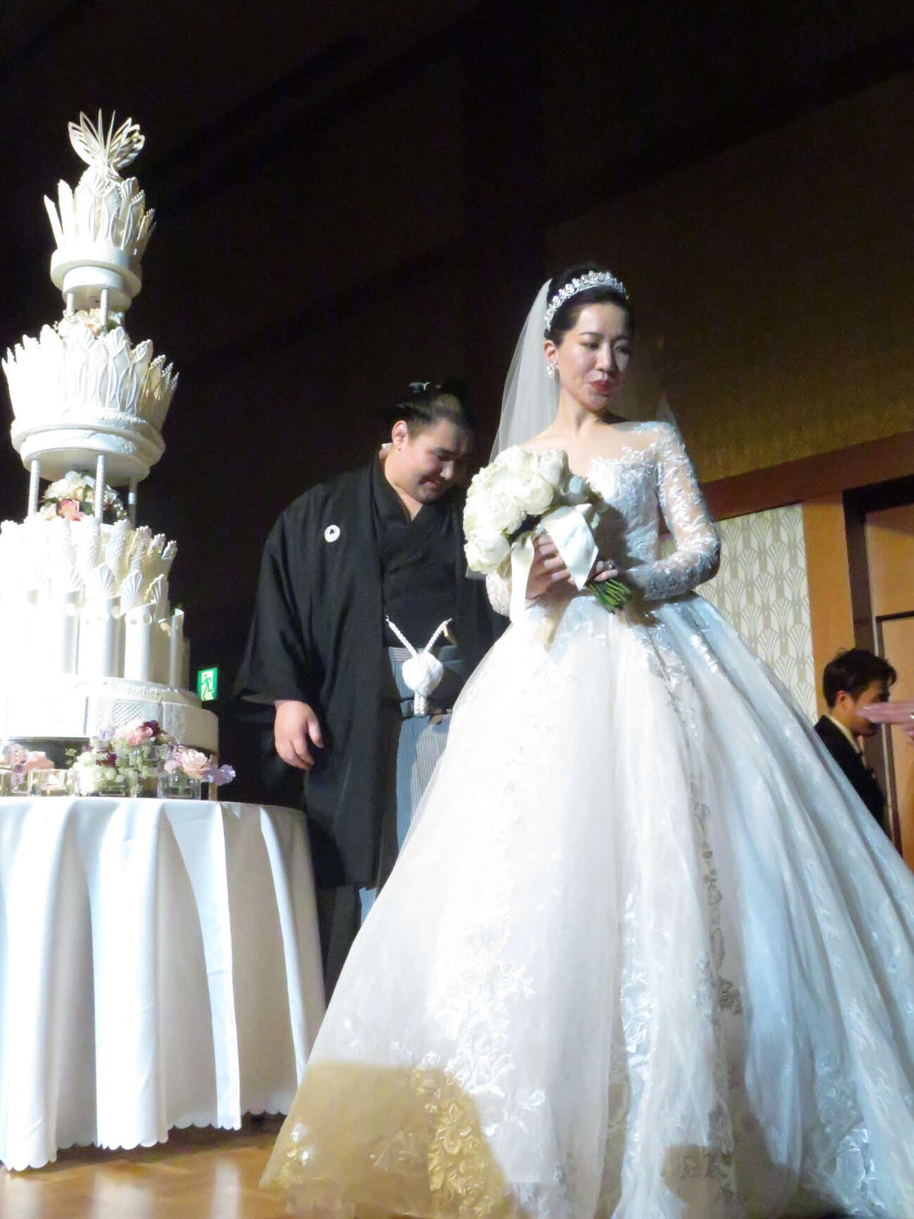 結婚披露宴でケーキ入刀後、ステージを降りる欧勝馬（左）と夫人