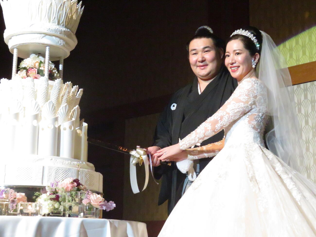 結婚披露宴でケーキに入刀する欧勝馬（左）と夫人
