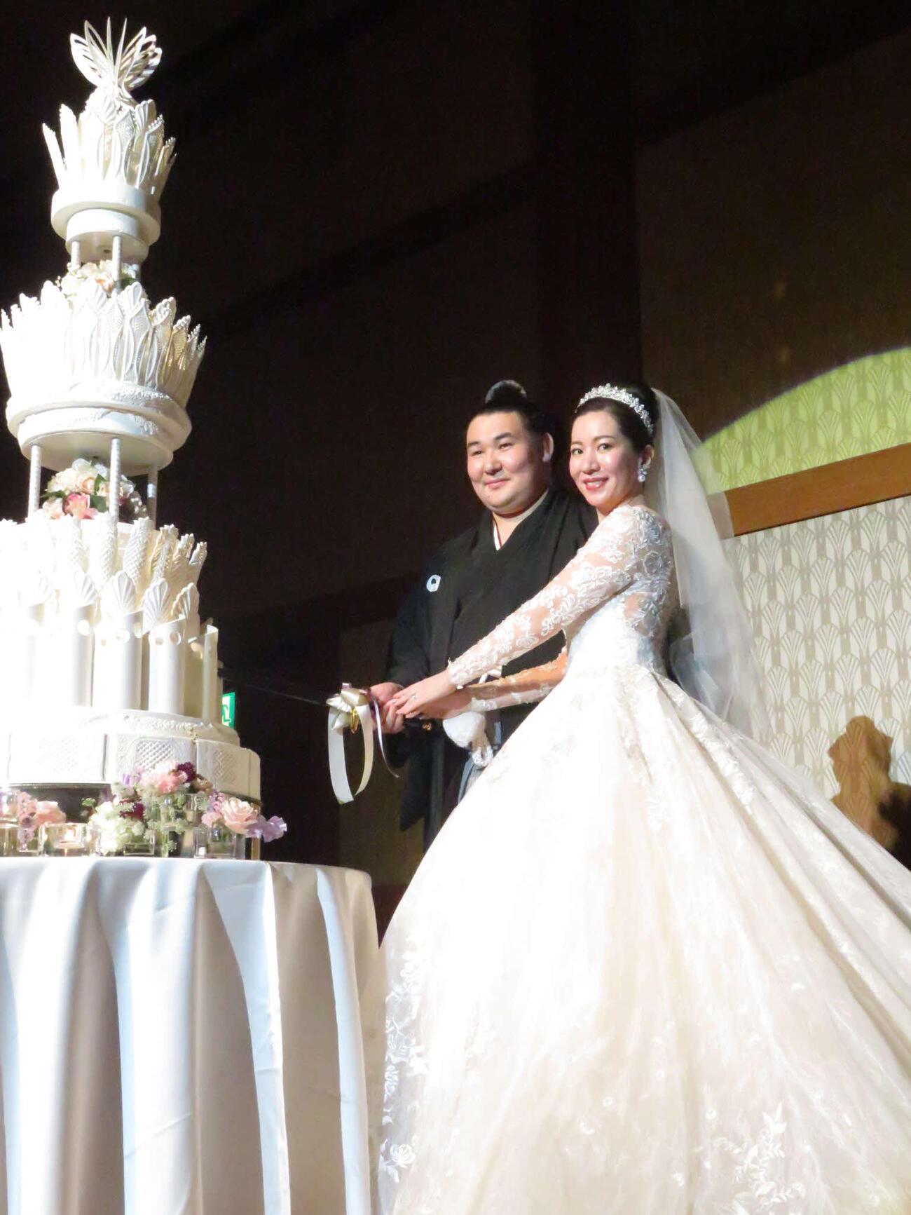 結婚披露宴でケーキに入刀する欧勝馬（左）と夫人