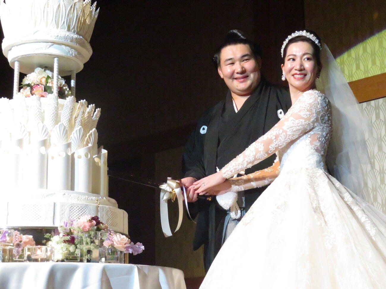 結婚披露宴でケーキに入刀する欧勝馬（左）と夫人