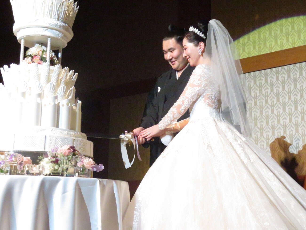 結婚披露宴でケーキに入刀する欧勝馬（左）と夫人