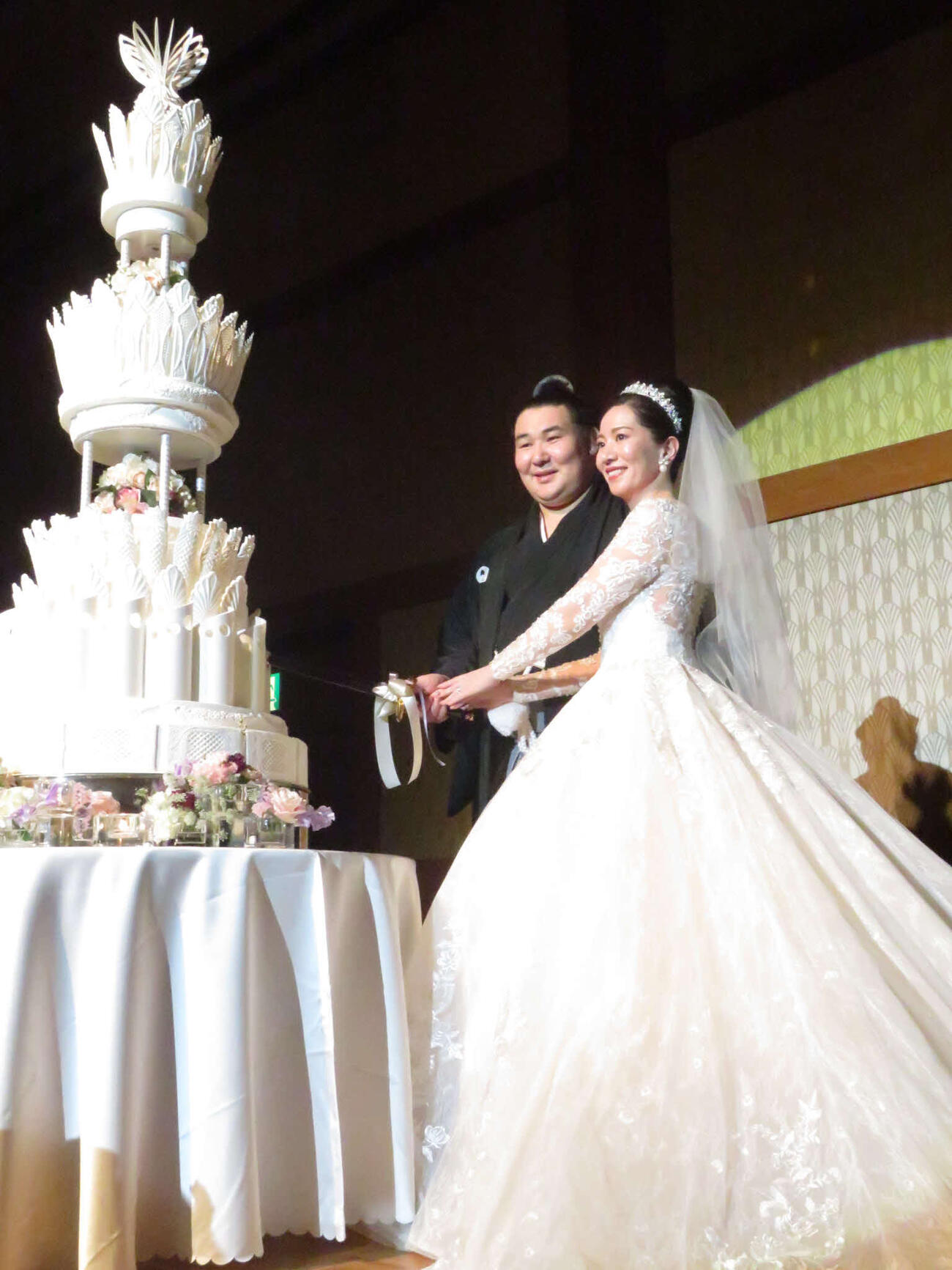 結婚披露宴でケーキに入刀する欧勝馬（左）と夫人
