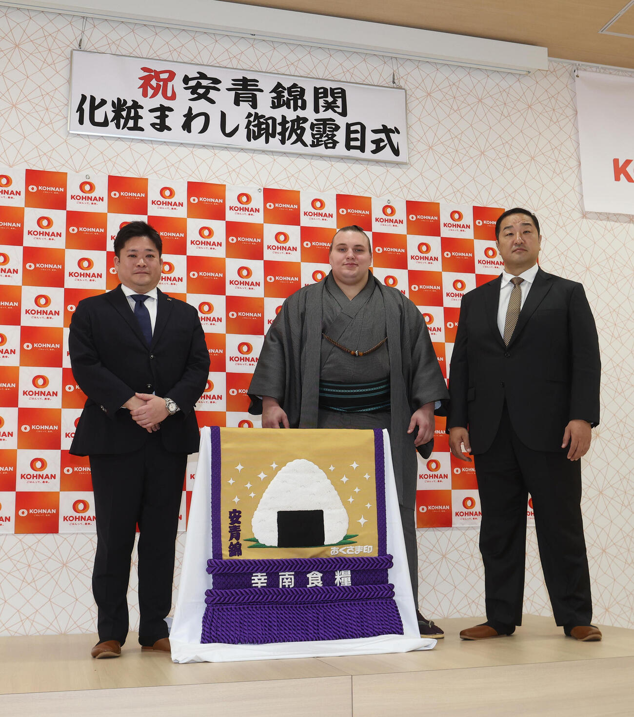 新しい化粧まわしをお披露目する、左から幸南食糧の川西孝彦代表取締役、安青錦、安治川親方（撮影・白石智彦）