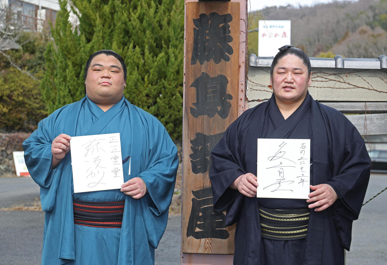 藤島部屋の看板前で目標を書いた色紙を持つ新入幕の藤凌駕（左）と藤青雲（撮影・白石智彦）