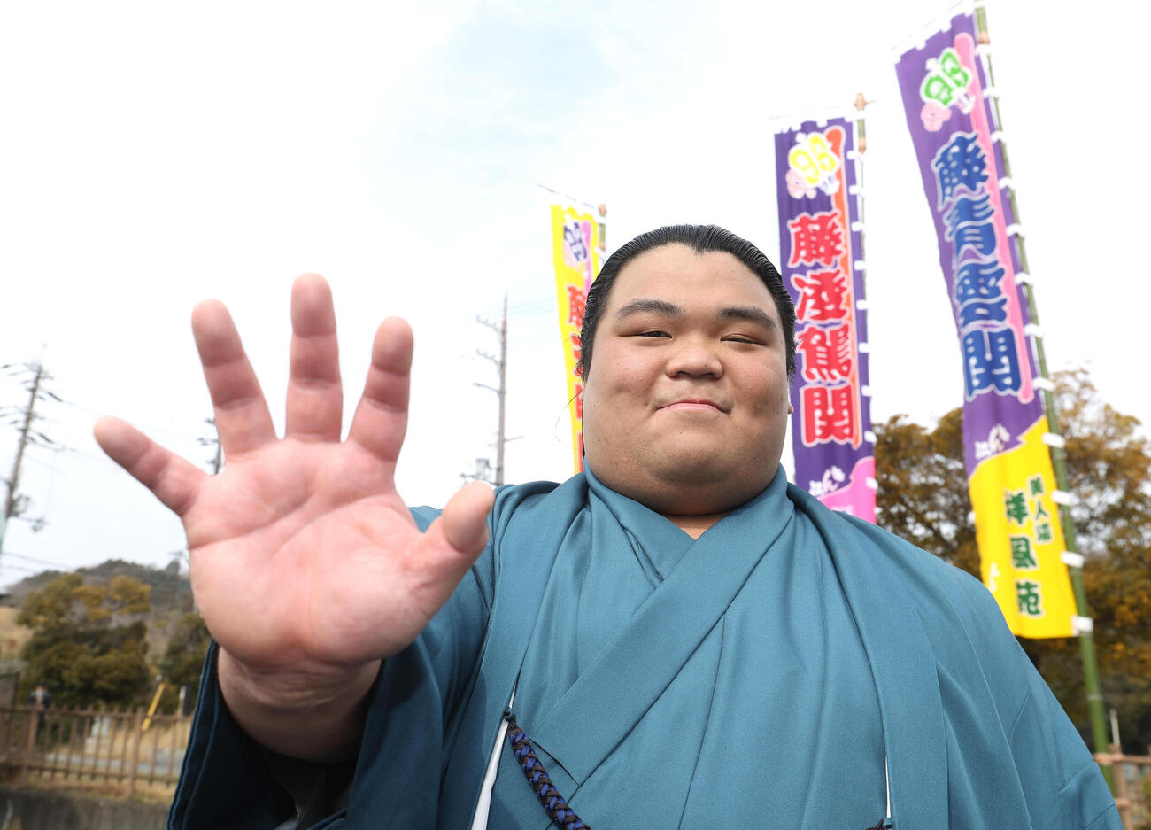 のぼりを背に得意の押し相撲のポーズをとる新入幕の藤凌駕（撮影・白石智彦）