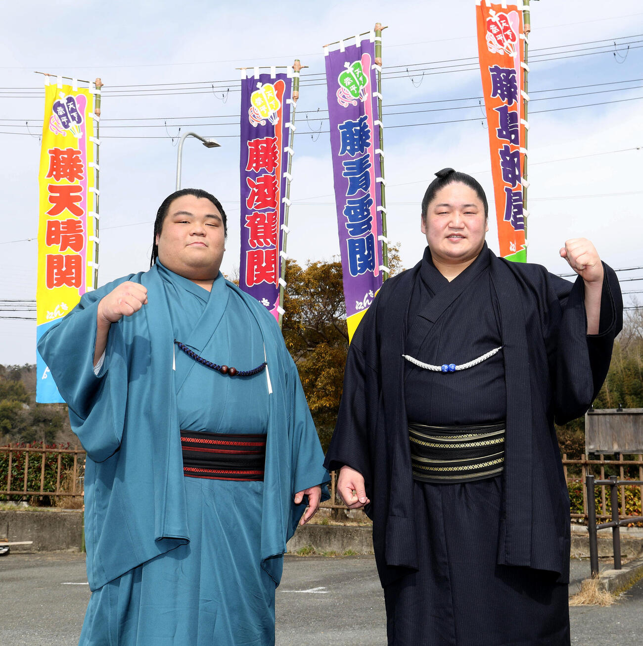 のぼりを背にガッツポーズする新入幕の藤凌駕（左）と藤青雲（撮影・白石智彦）