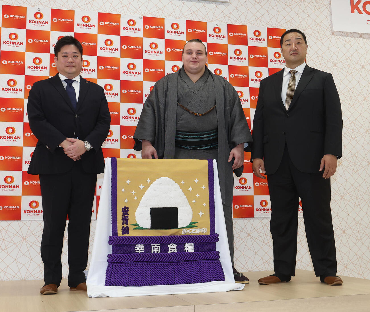 新しい化粧まわしをお披露目する、左から幸南食糧の川西孝彦代表取締役、安青錦、安治川親方（撮影・白石智彦）