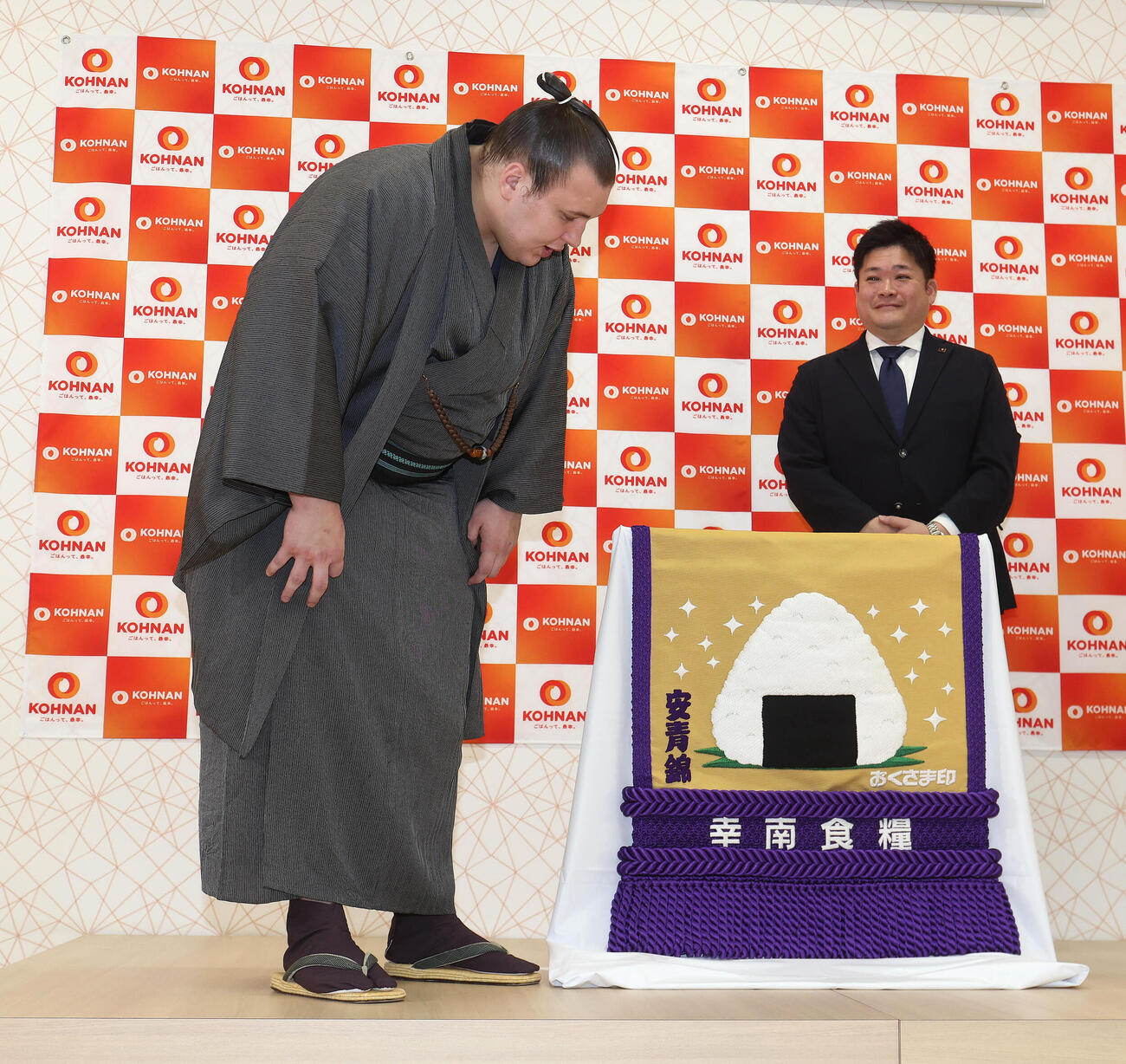 新しい化粧まわしを見る安青錦。右は幸南食糧の川西孝彦代表取締役（撮影・白石智彦）
