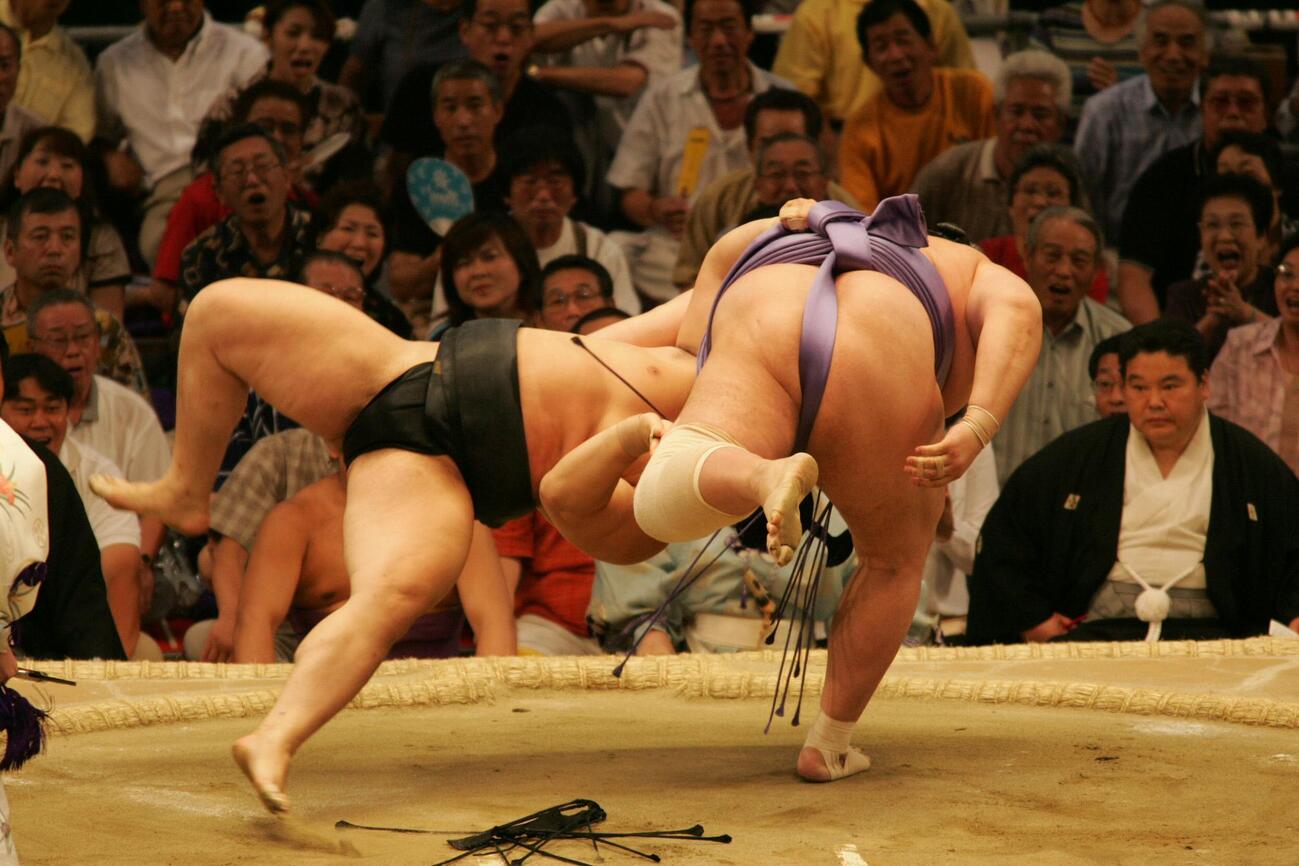 朝青龍（左）は琴ノ若の上手投げを、裏返しになりながら、まわしにしがみついて残し同体とする（04年07月撮影）