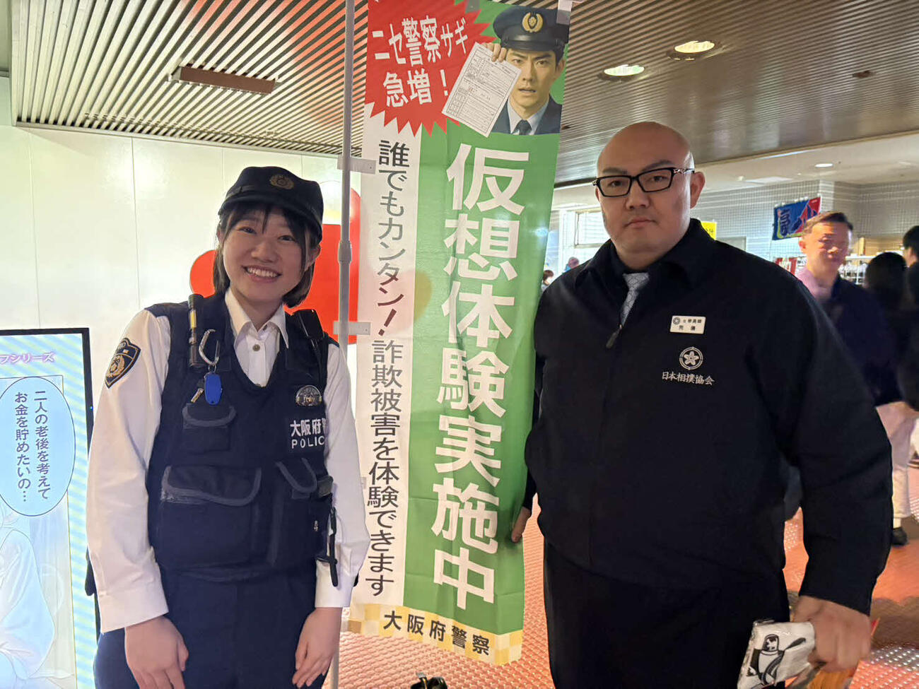 大阪府警によるニセ警察詐欺の仮想体験をした荒磯親方（右）