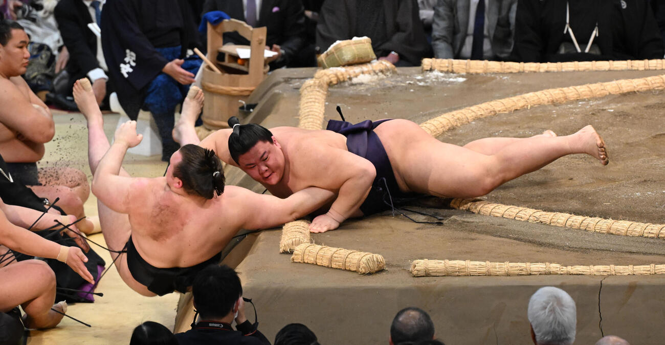 安青錦（左）を寄り倒しで破る義ノ富士