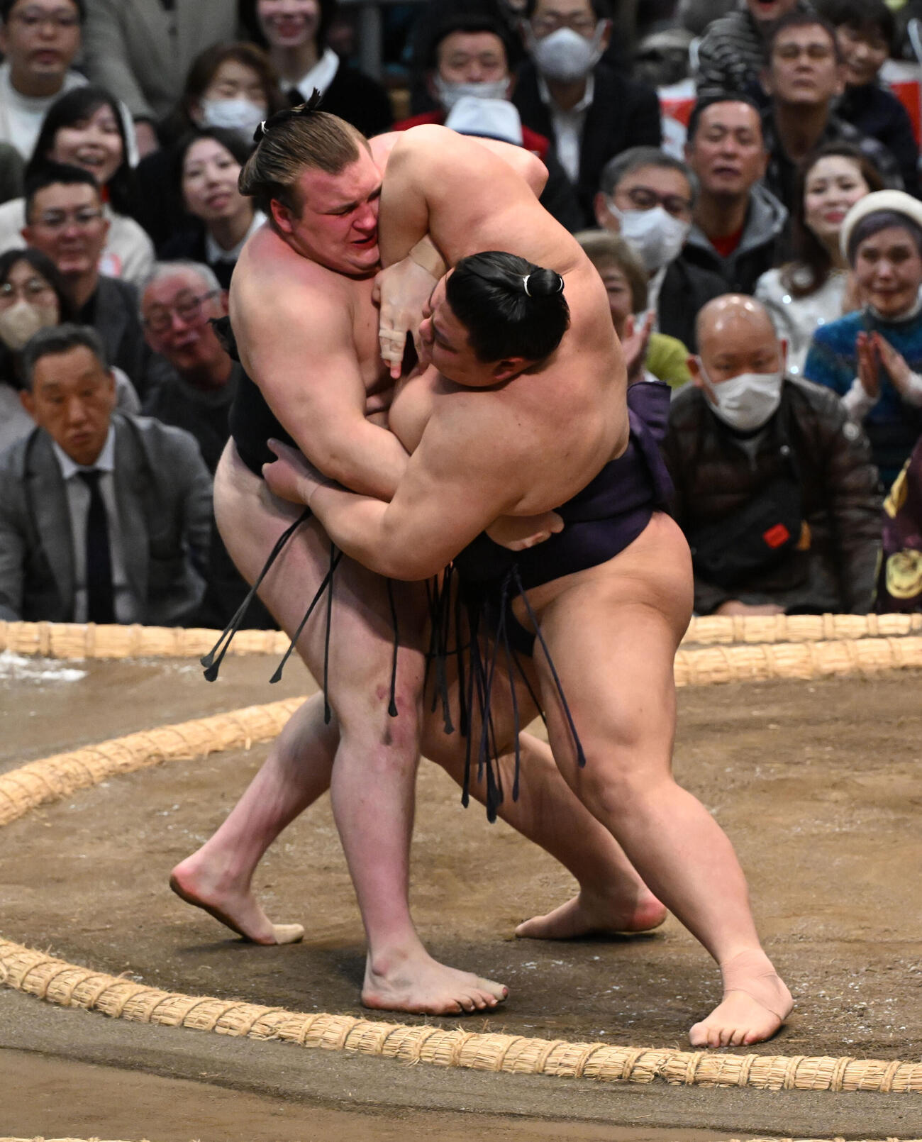 安青錦（左）を寄り倒しで破る義ノ富士
