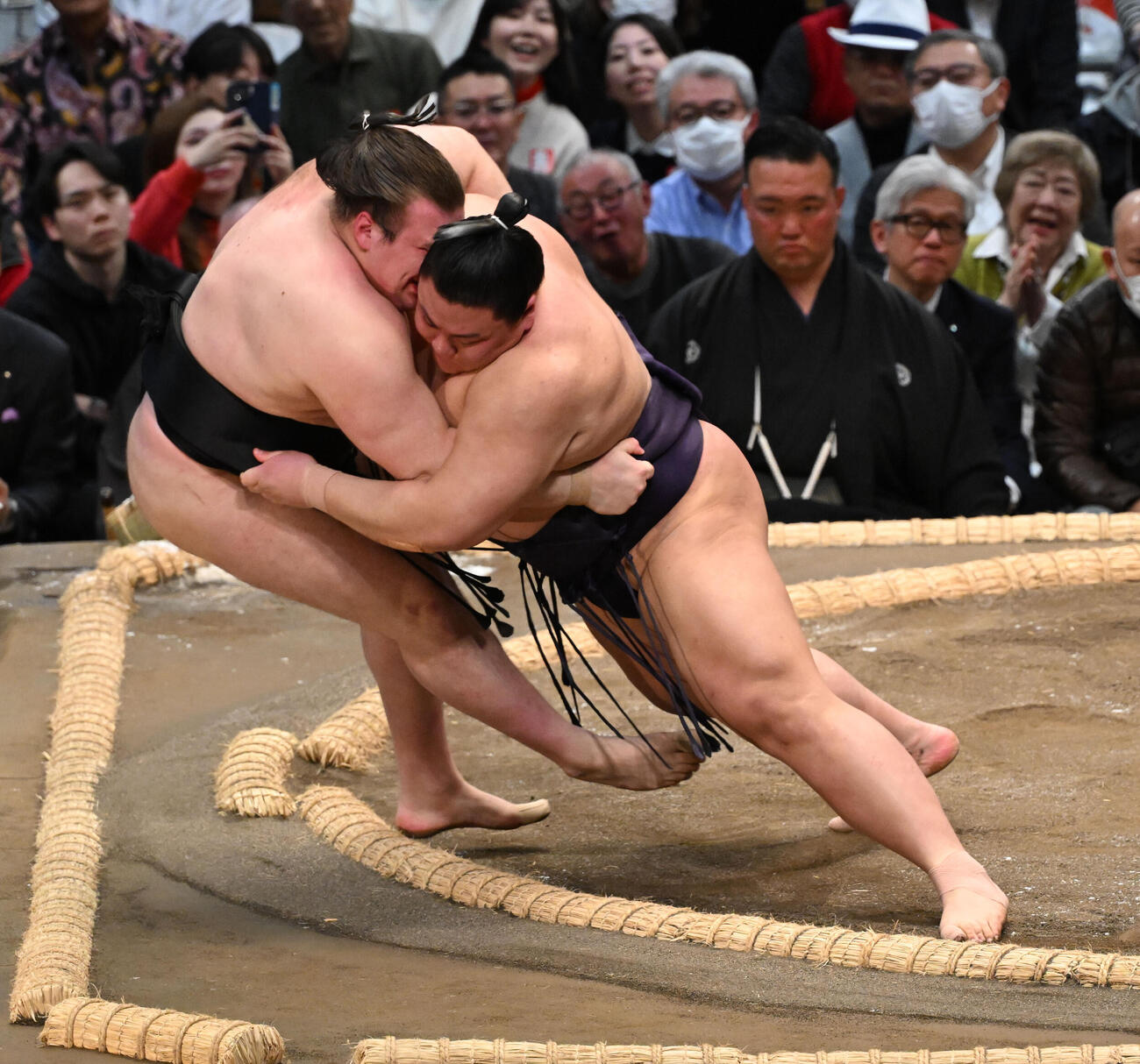 安青錦（左）を寄り倒しで破る義ノ富士