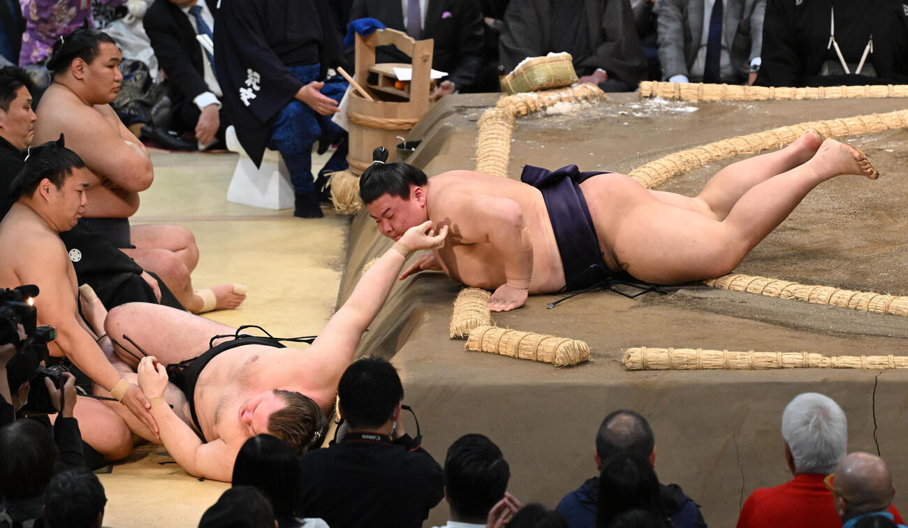 安青錦（左）を寄り倒しで破る義ノ富士
