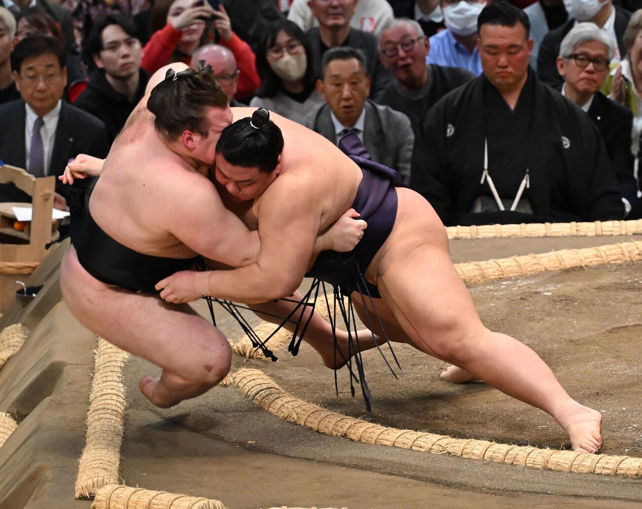 安青錦（左）を寄り倒しで破る義ノ富士