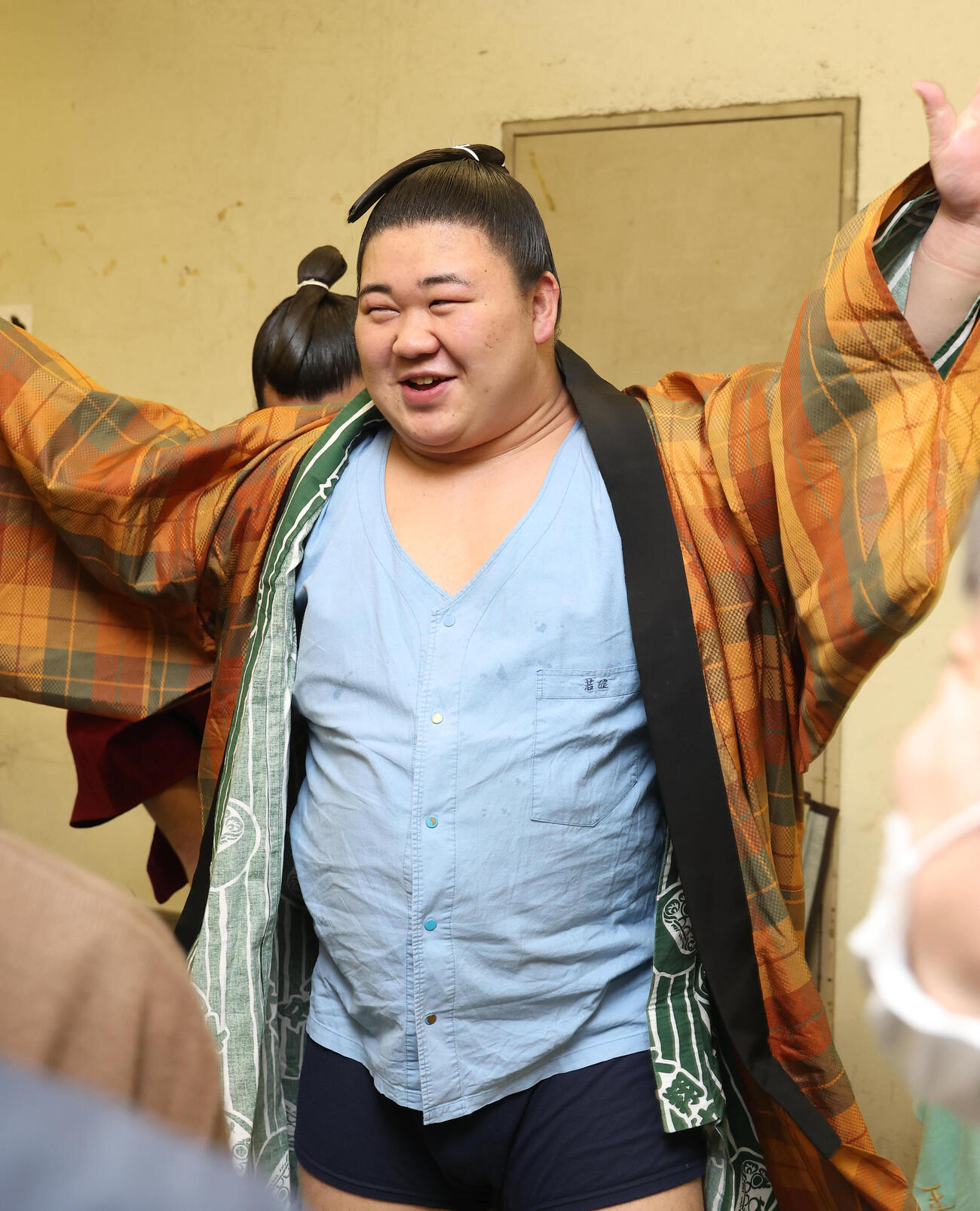 支度部屋で藤ノ川は笑顔で着替える