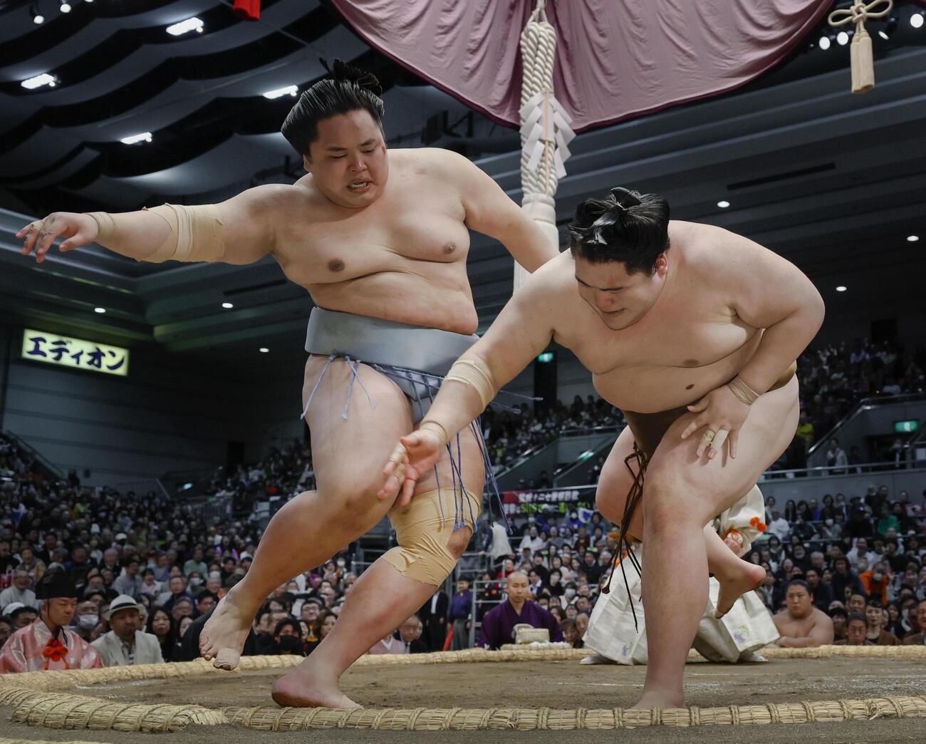 琴勝峰（左）が突き落としで王鵬を破る（共同）