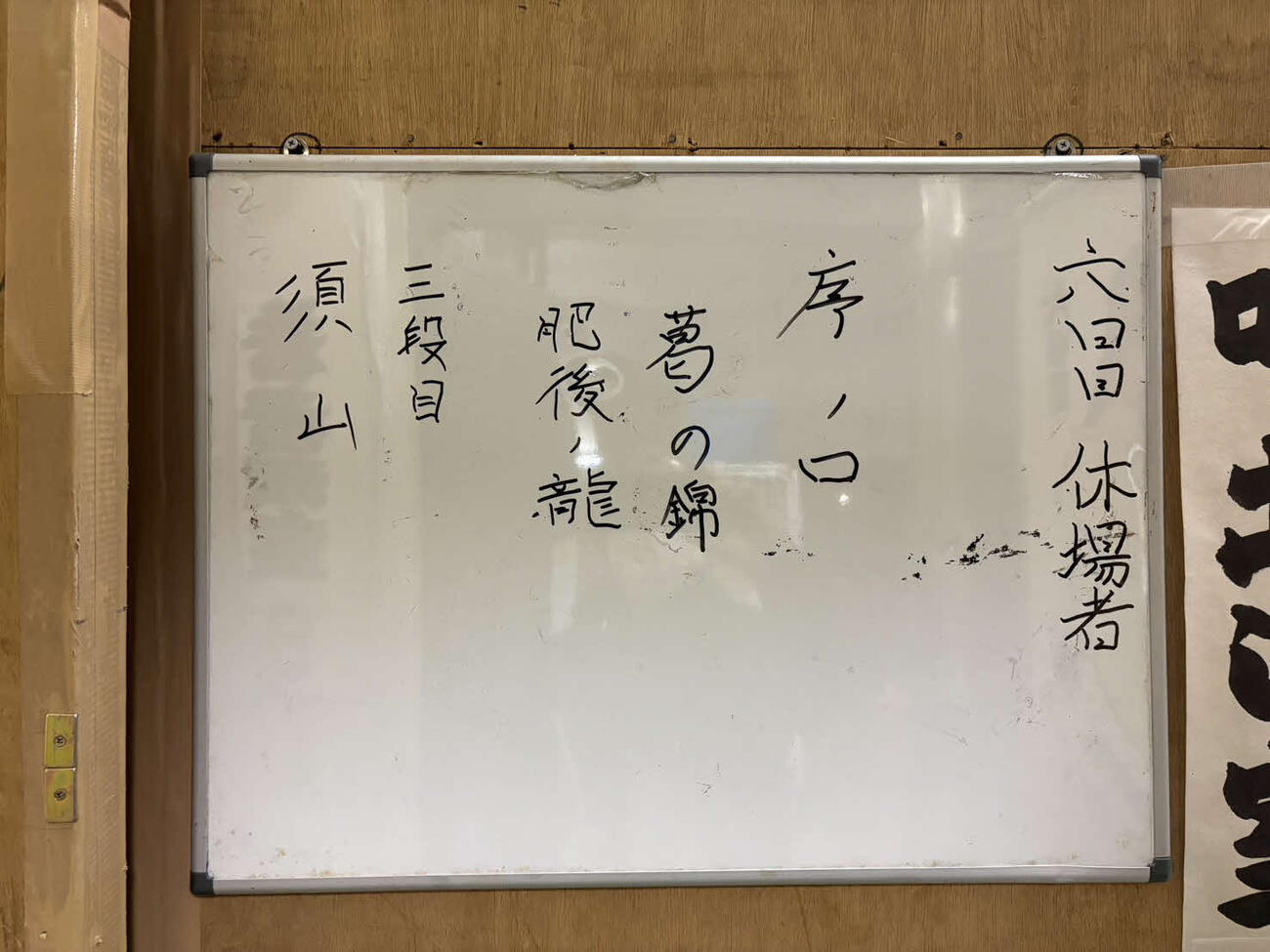 葛の錦と肥後ノ龍の休場を伝える館内のホワイトボード
