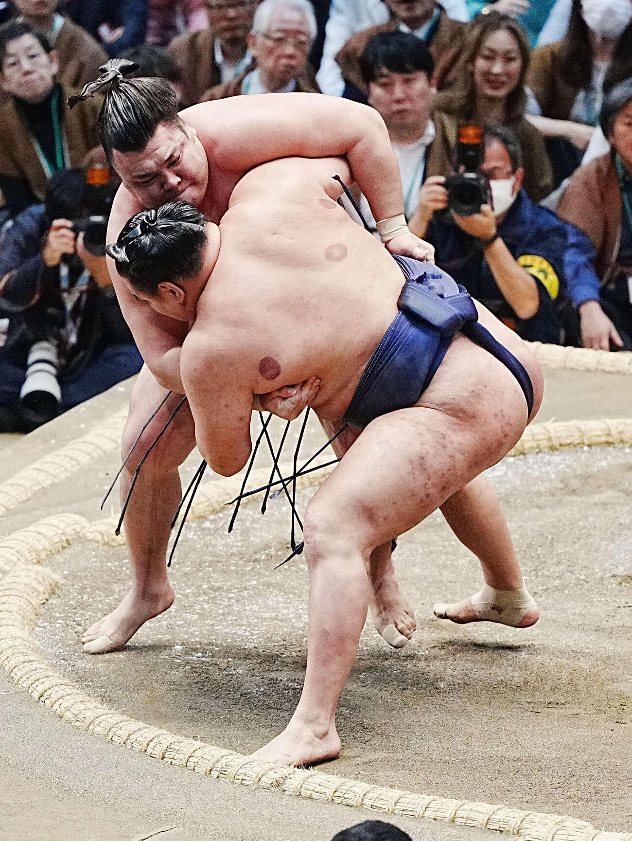 豊昇龍（手前）を土俵際へ攻め込む霧島（撮影・小沢裕）