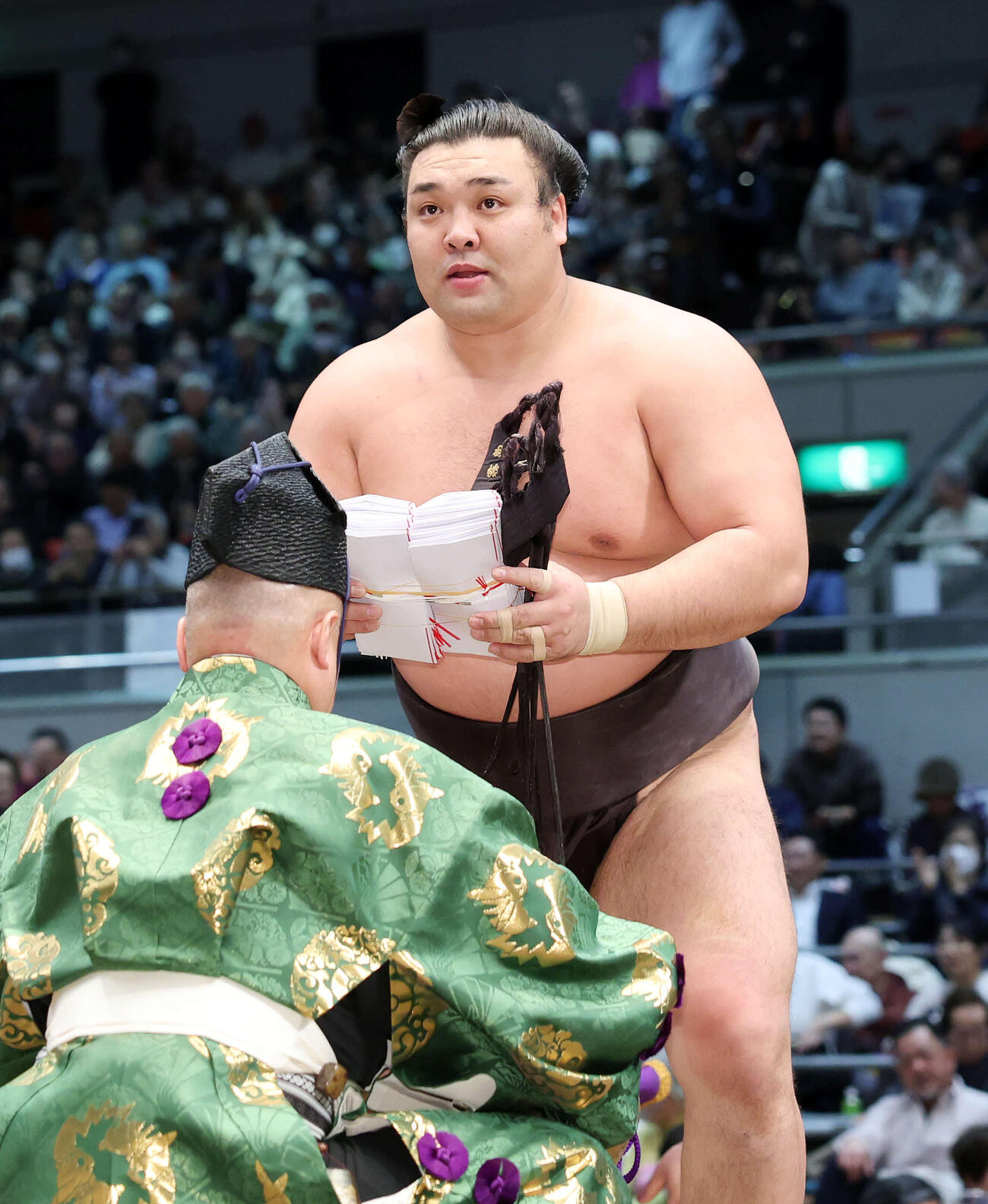 懸賞金の束を手に土俵を引き揚げる霧島（撮影・鈴木正人）　