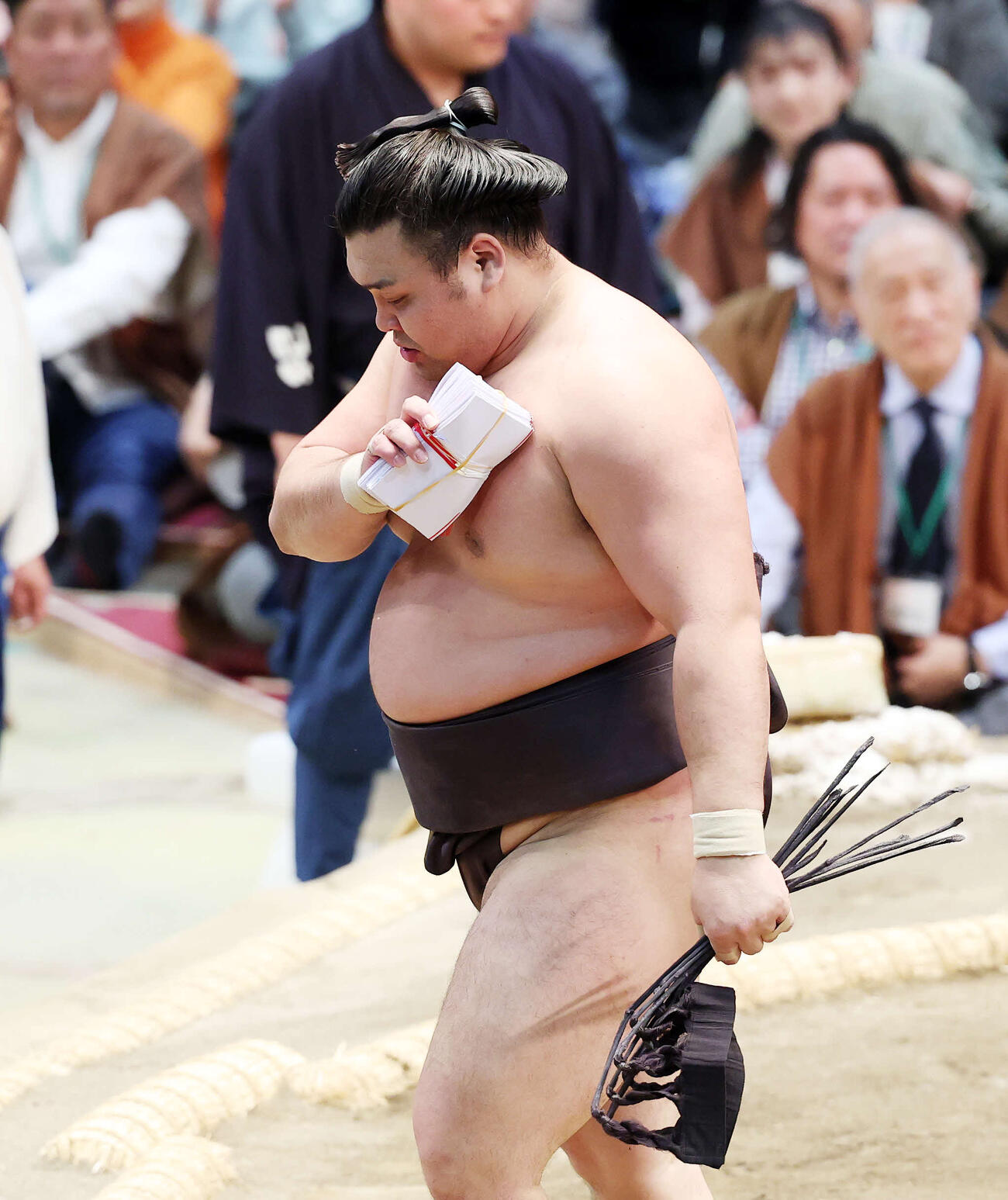 懸賞金の束を手に土俵を引き揚げる霧島（撮影・鈴木正人）　