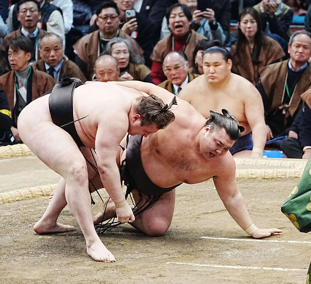 霧島は安青錦（左）に下手投げで敗れる。右は土俵下控えの豊昇龍（撮影・小沢裕）