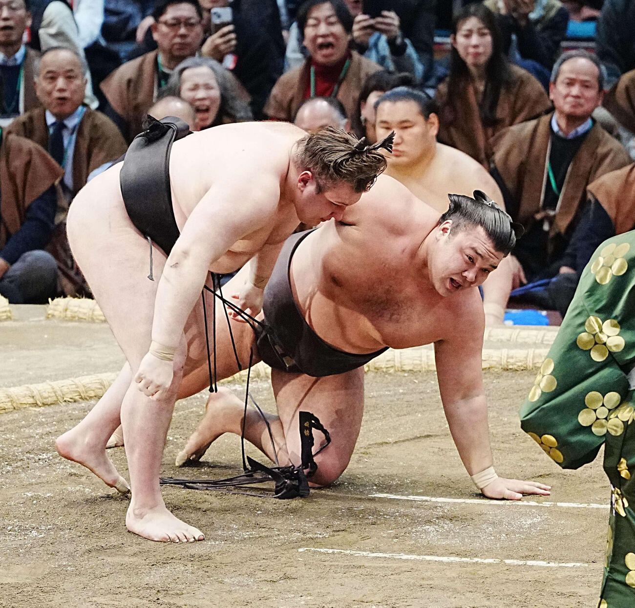 霧島は安青錦（左）に下手投げで敗れる。後方は土俵下控えの豊昇龍（撮影・小沢裕）