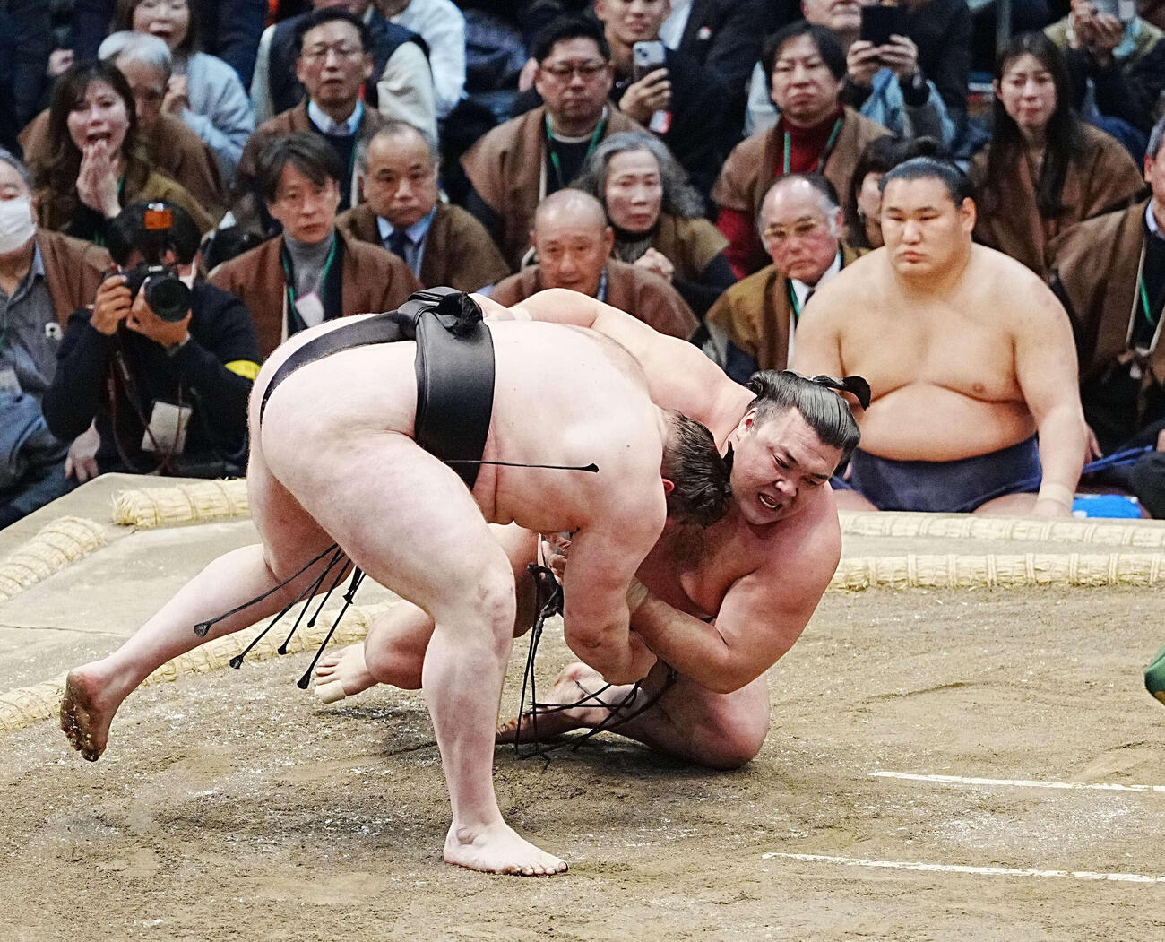 霧島は安青錦（左）に下手投げで敗れる。右は土俵下控えの豊昇龍（撮影・小沢裕）