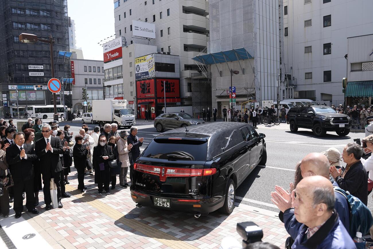 大勢のファンに見守られながら移動する、元大関若嶋津の日高六男さんのひつぎを乗せた霊きゅう車（撮影・河田真司）