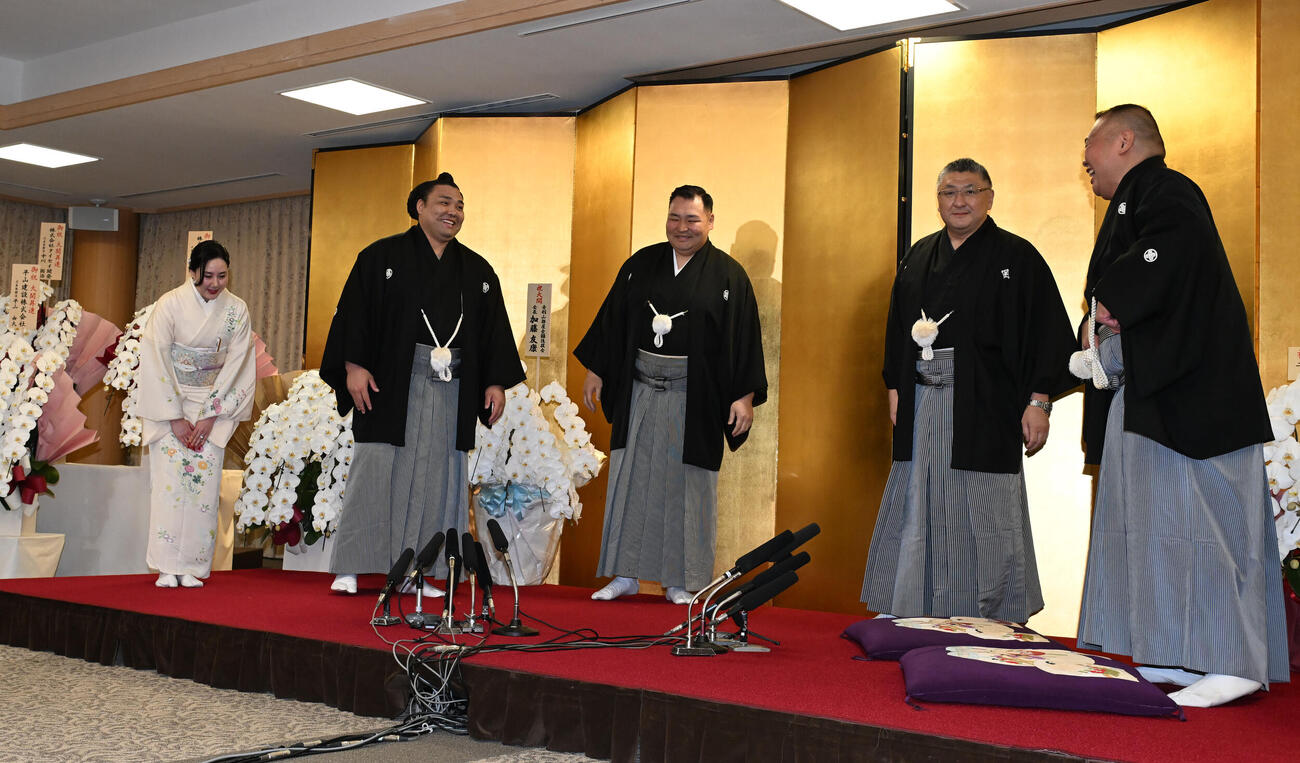 大関昇進の伝達式を終え、緊張がとけた霧島は笑顔を見せる、右隣は師匠の音羽山親方、左はおかみのムンフザヤ夫人（撮影・和賀正仁）