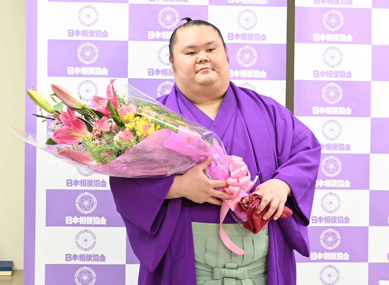引退会見で花束を受け取る千代丸（撮影・飯岡大暉）