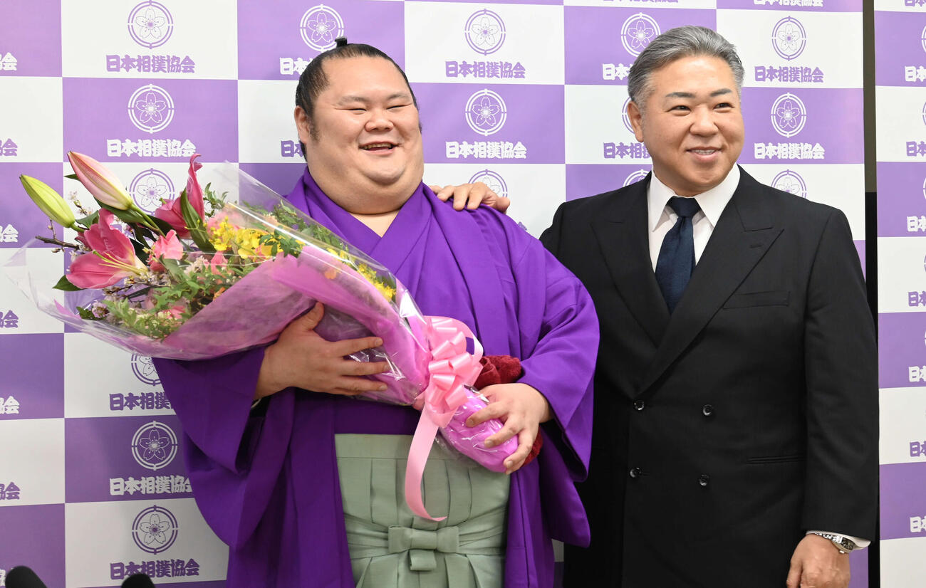 引退会見で、花束を手にする千代丸（左）と九重親方（撮影・飯岡大暉）