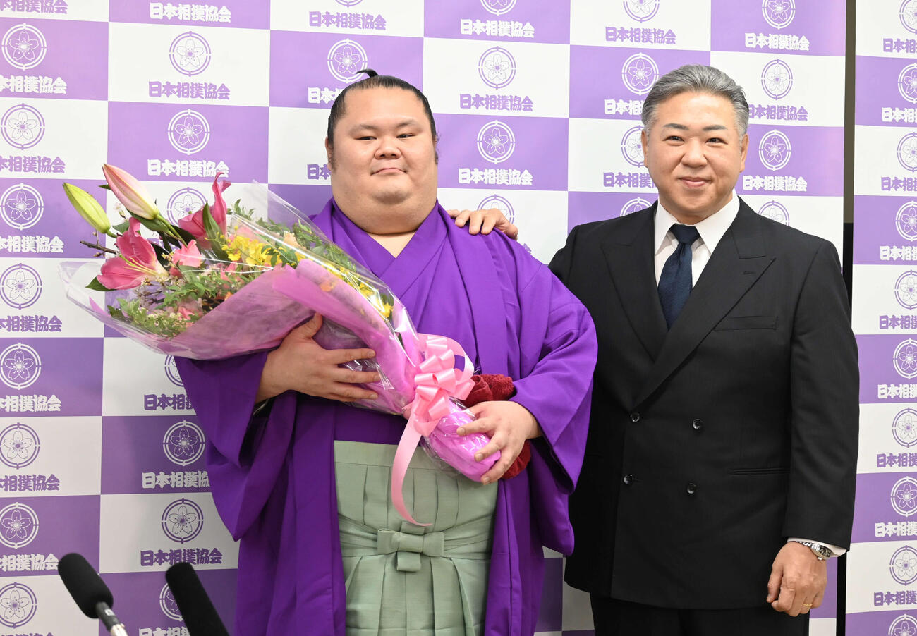 引退会見で、花束を手にする千代丸（左）と九重親方（撮影・飯岡大暉）
